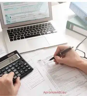 Munka idézet. Egy íróasztalon különböző papírok és egy számológép látható, valaki éppen adóbevallást vagy pénzügyi dokumentumokat tölt ki.